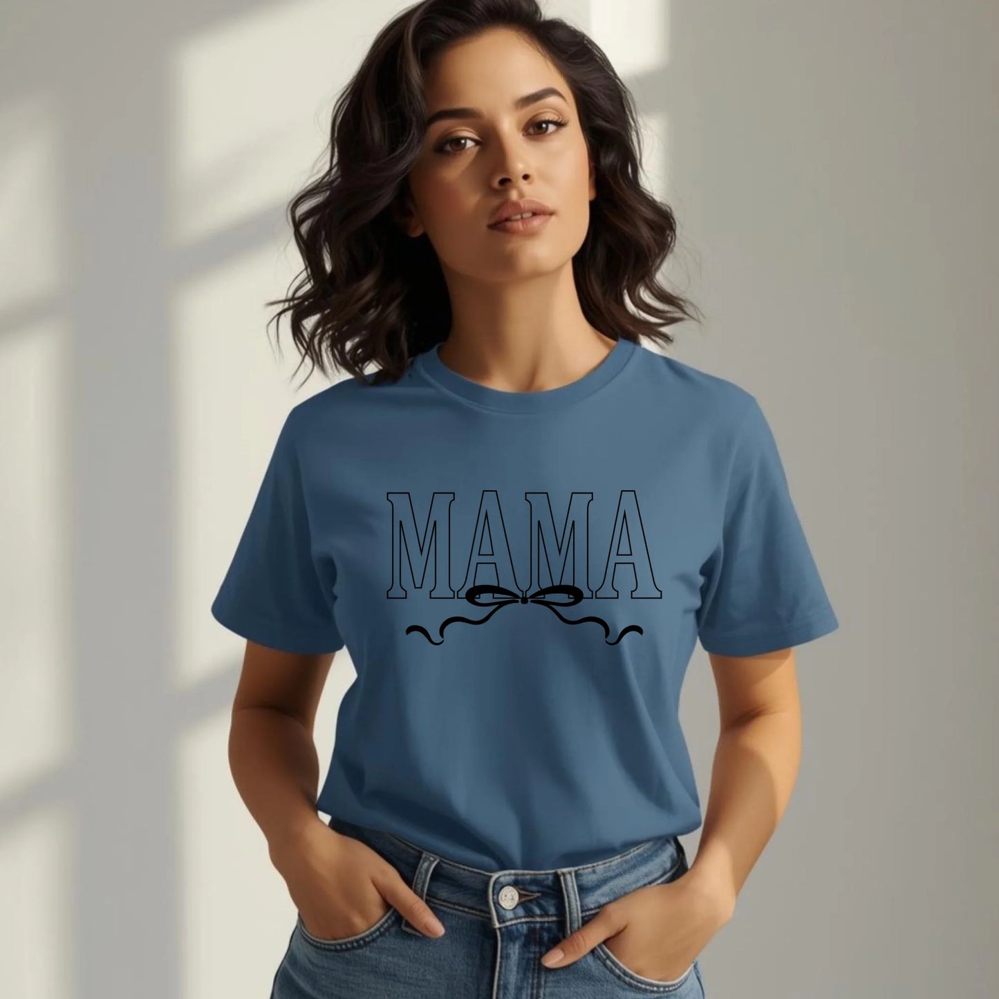 Woman wearing a blue t-shirt with 'MAMA' text and bow design.