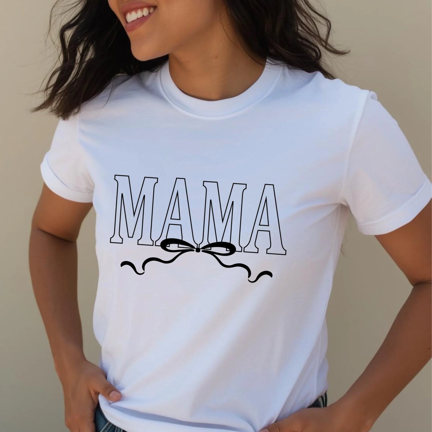 Person wearing a white t-shirt with 'MAMA' text and bow design.