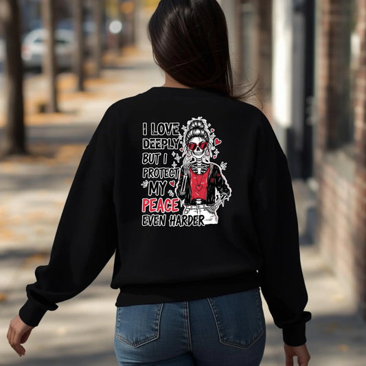 Black crewneck featuring back print “Love Hard Heal Harder” skeleton artwork, worn by woman walking outside, realistic lifestyle photo.