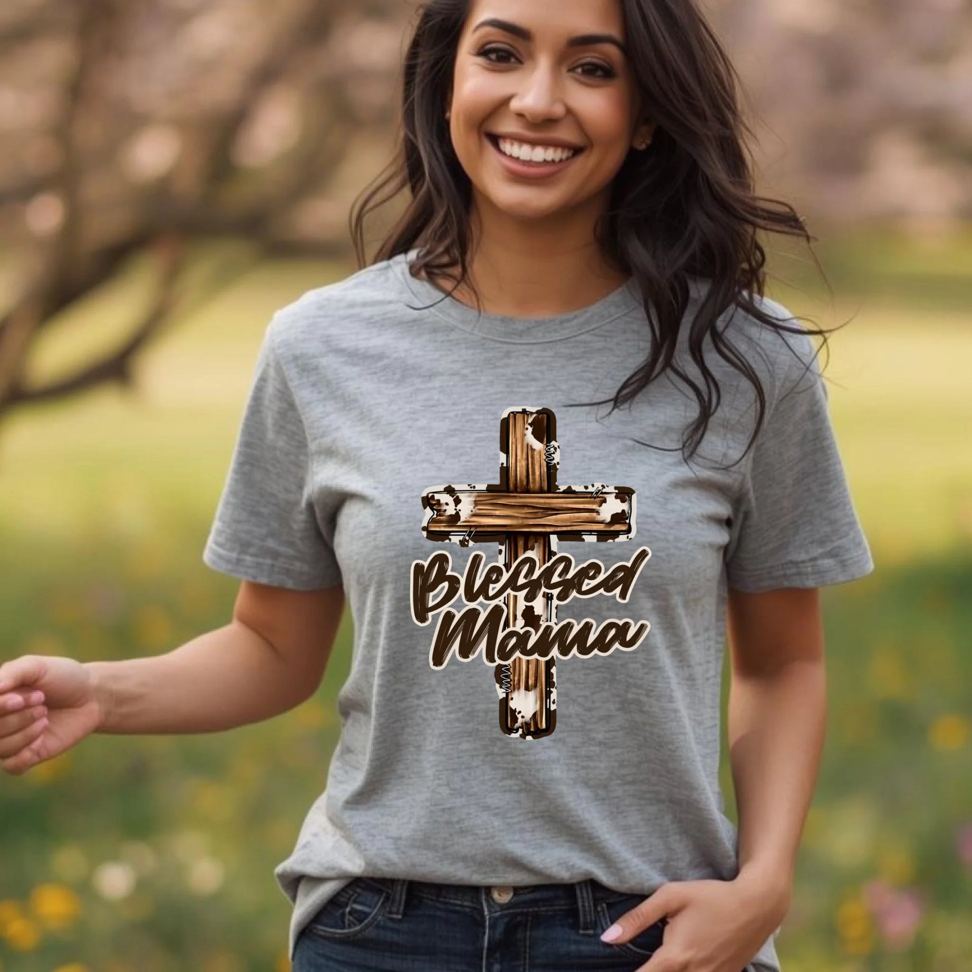 Lifestyle photo of a woman wearing a heather gray Bella Canvas t-shirt with a Blessed Mama cross design, natural movement outdoors.