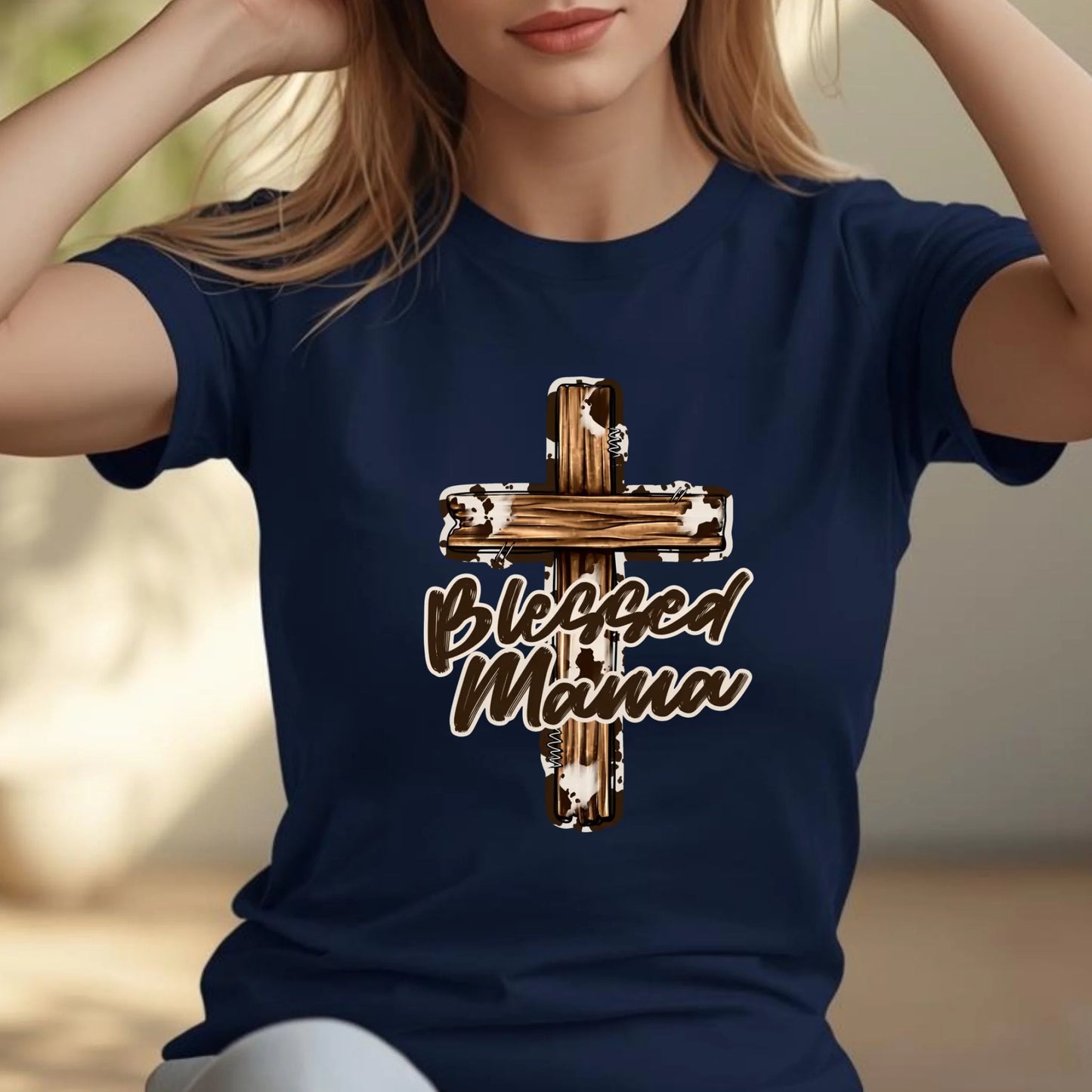 Torso view of a woman wearing a navy Blessed Mama cross shirt with arms raised, showing relaxed movement and fabric fit.