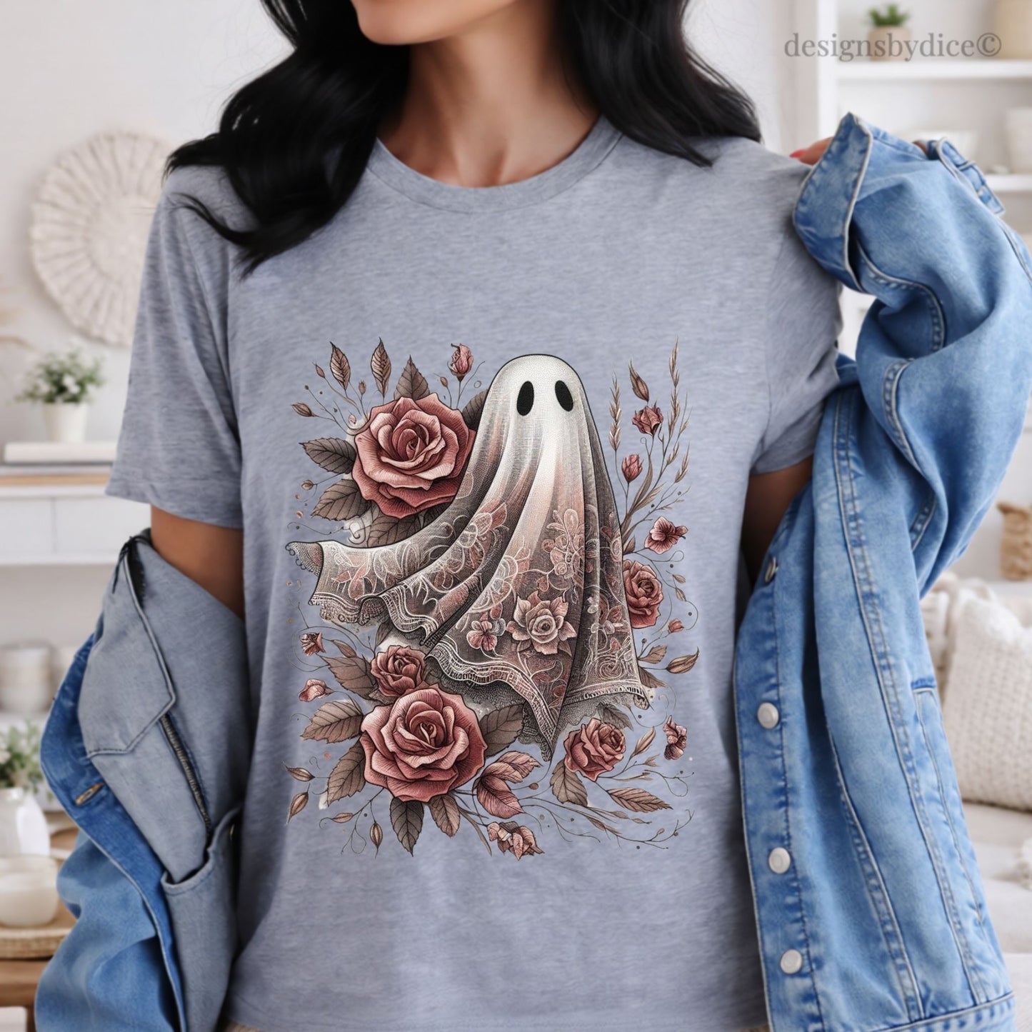 Person wearing a gray t-shirt with a floral ghost design, standing in a room.