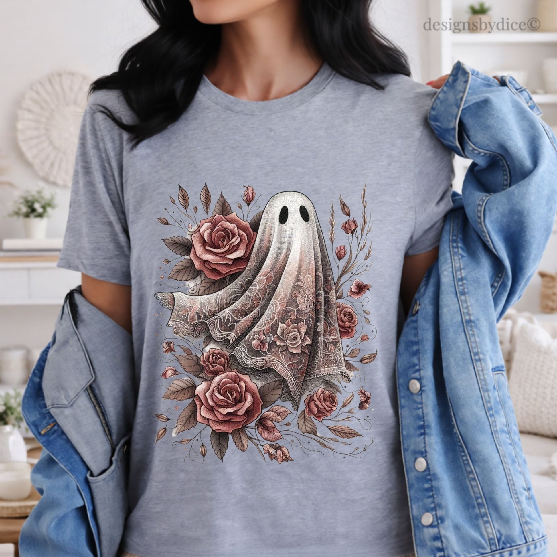 Person wearing a gray t-shirt with a floral ghost design, standing in a room.