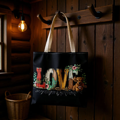 Black tote bag with 'LOVE' and bear design hanging on a wooden wall.