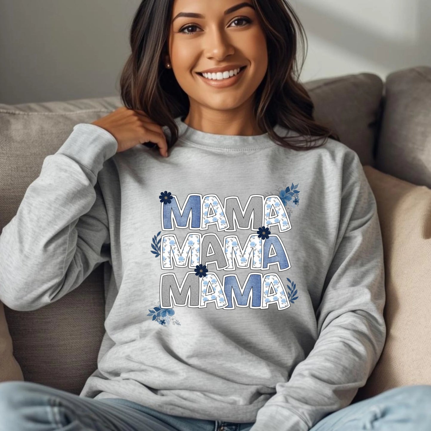 Woman lounging on a couch wearing a gray “Mama” floral crewneck sweatshirt with botanical lettering.