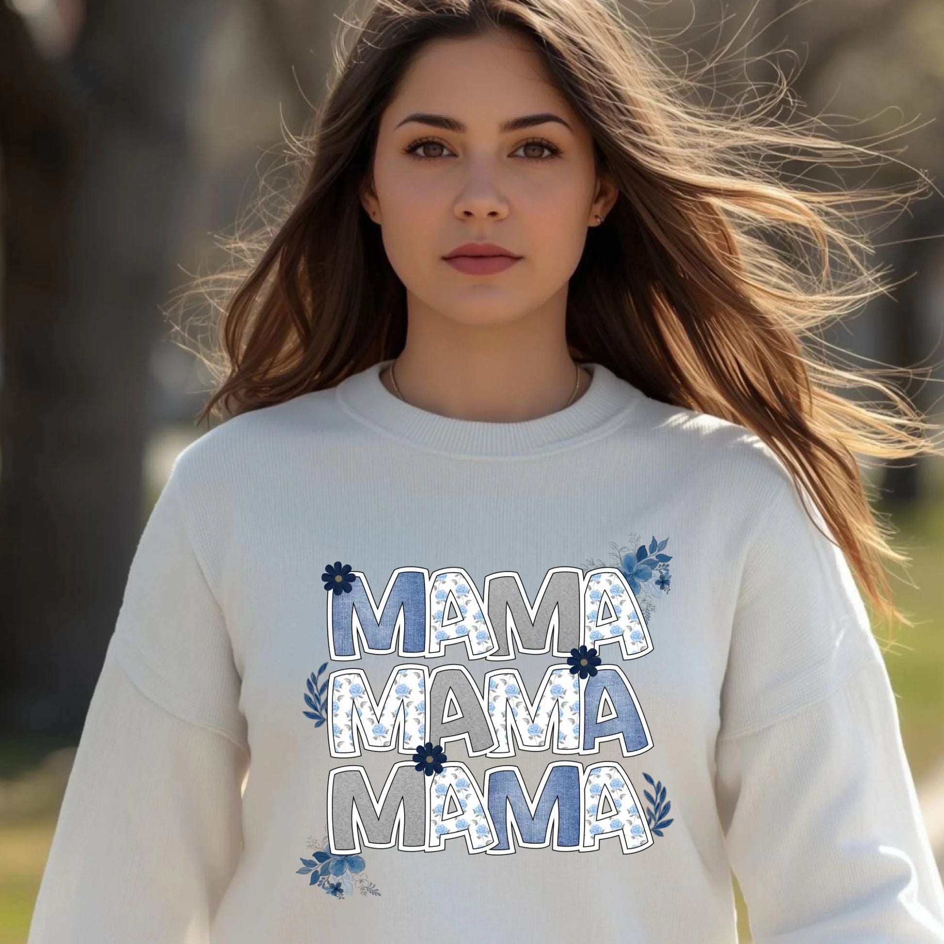 Woman wearing a white floral “Mama” crewneck sweatshirt styled in soft neutral tones.