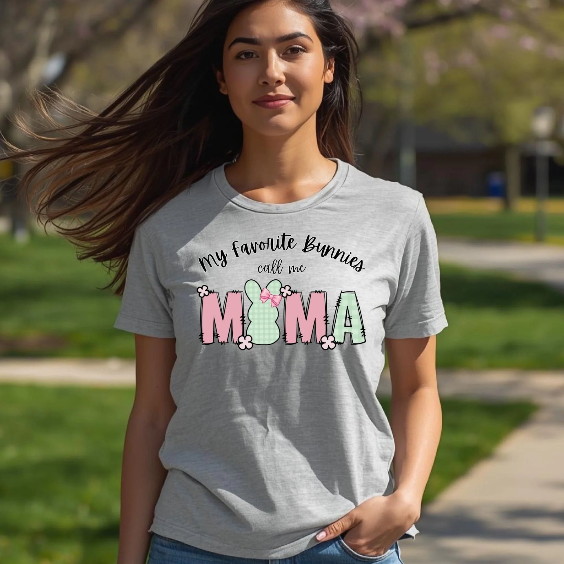 Model wearing a heather gray Bella Canvas t-shirt with an Easter bunny Mama graphic, photographed outdoors in natural daylight.