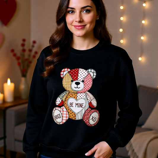 Black cozy crewneck with patchwork valentine teddy bear holding heart and stitched accents.
