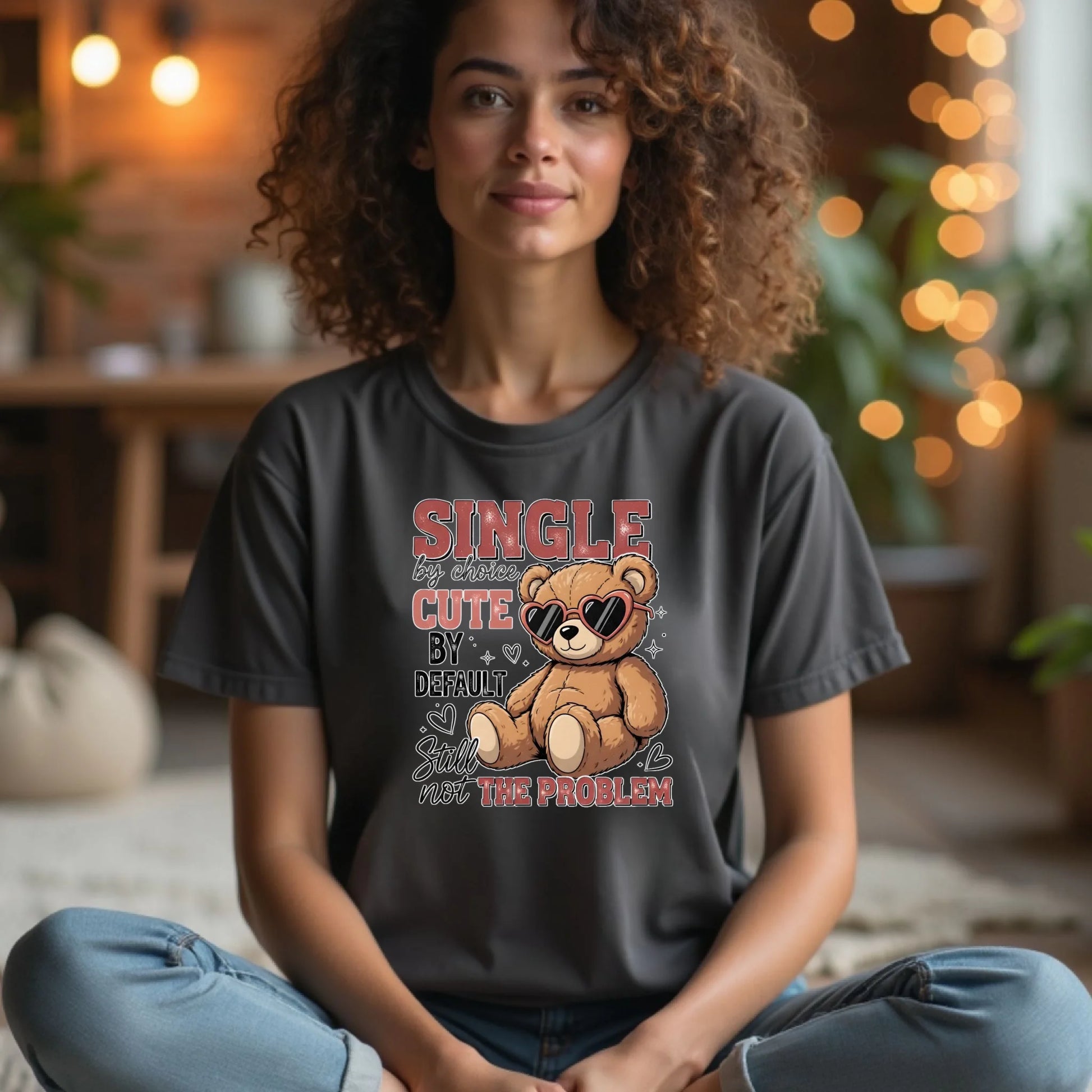 Person wearing a t-shirt with a teddy bear graphic and text in a cozy indoor setting.