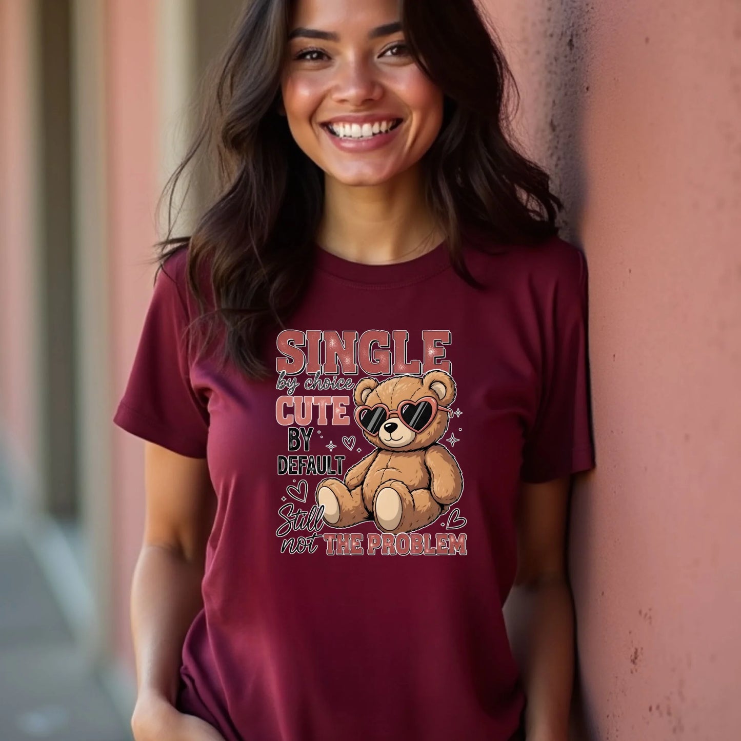 Woman wearing a maroon t-shirt with a teddy bear graphic and text.