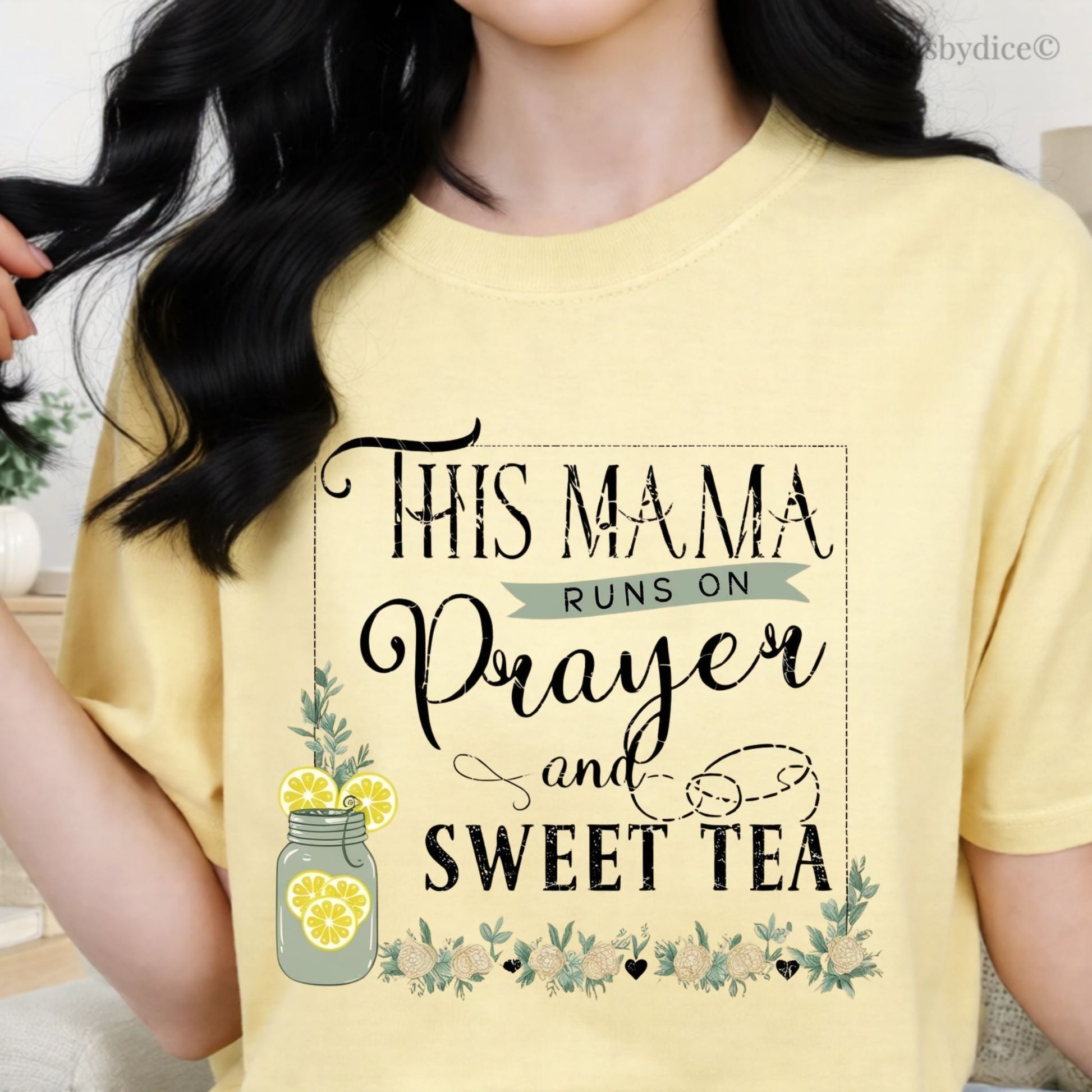 butter colored t-shirt with text 'This mama runs on prayer and sweet tea' worn by a person.