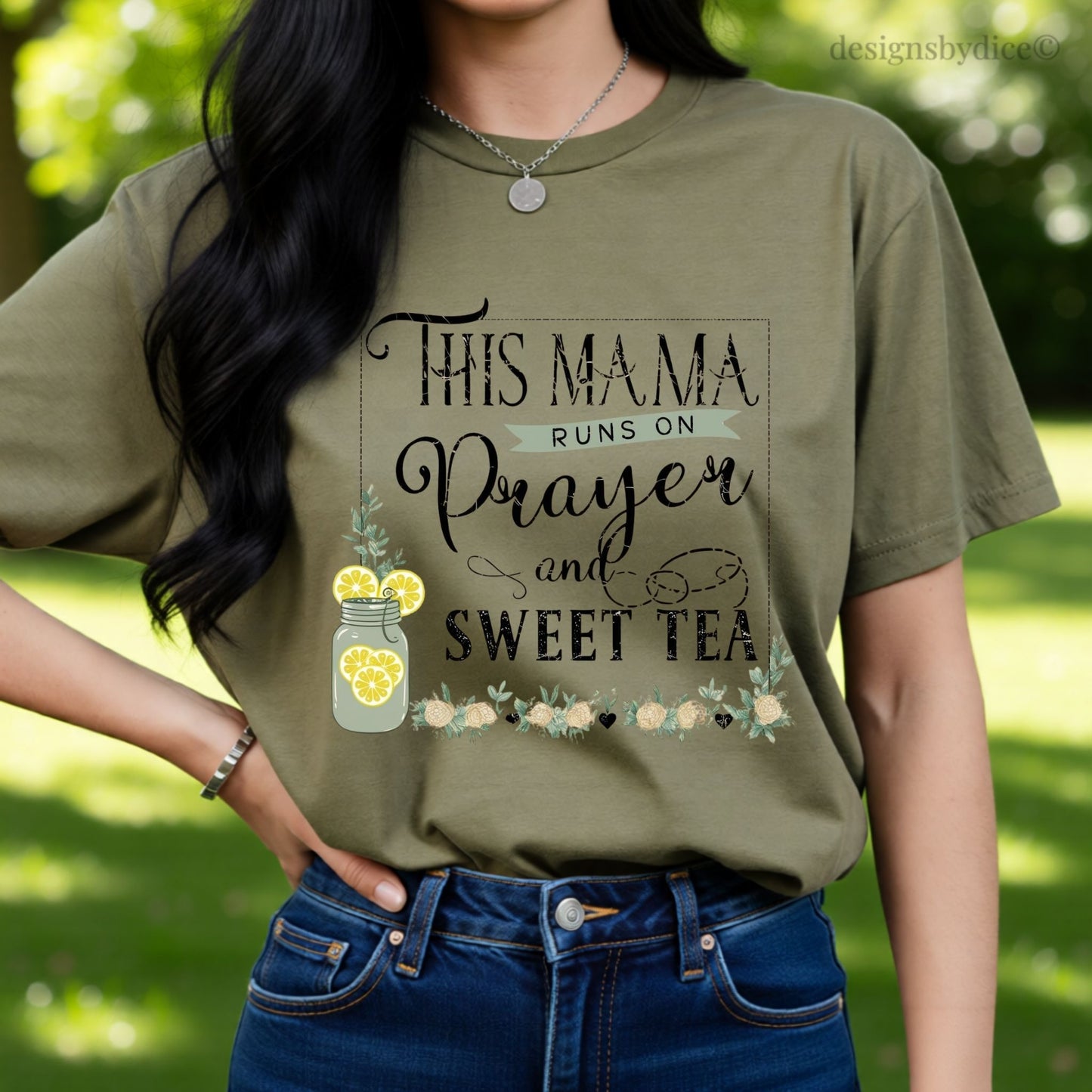 Person wearing a t-shirt with text 'This Mama runs on Prayer and Sweet Tea' in an outdoor setting.